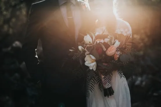 chauffeur privé mariage toulouse Mariée en robe blanche tenant un bouquet de fleurs.