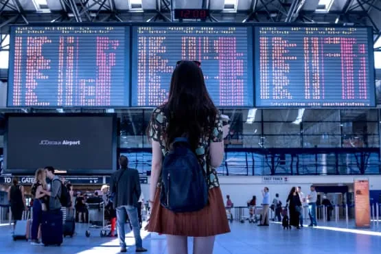 Voyageurs avec leurs bagages dans un terminal d’aéroport.