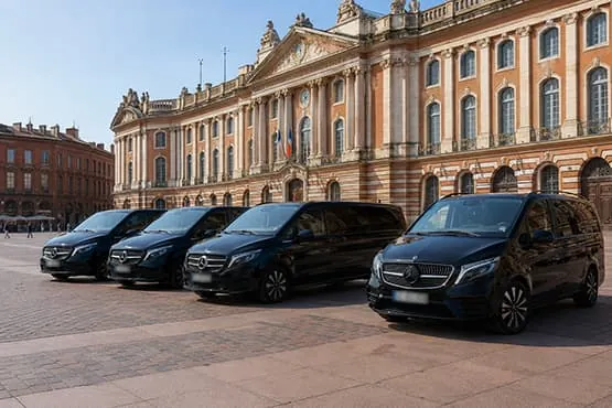 Réserver VTC Toulouse Driver Flotte de véhicules avec chauffeur stationnés devant un bâtiment en briques.