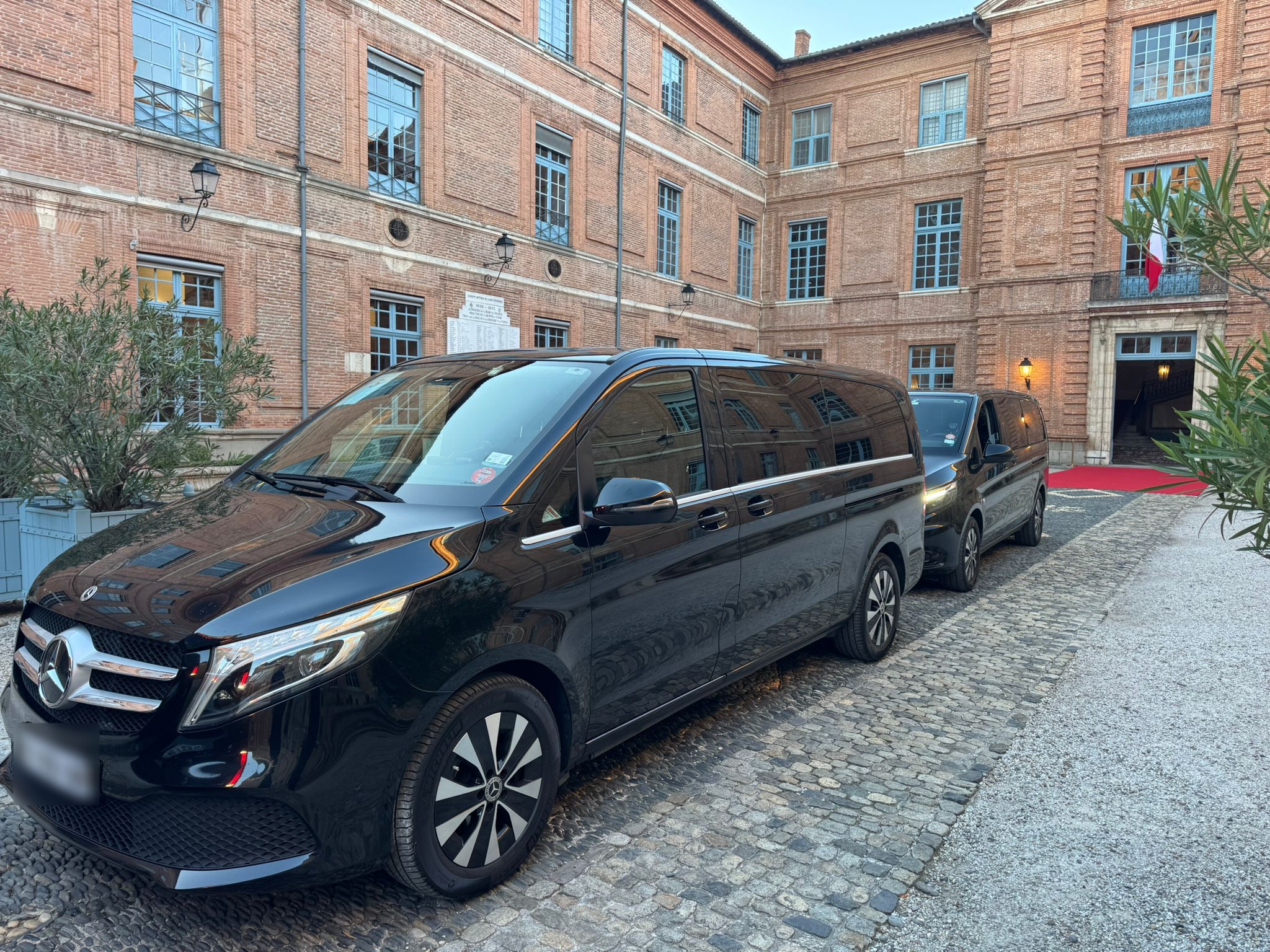 Van Mercedes noir de Toulouse Driver devant une façade en briques à Toulouse.